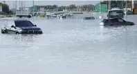  ?? AP-Yonhap ?? Vehicles sit abandoned in floodwater­s covering a road in Dubai, United Arab Emirates, Wednesday.