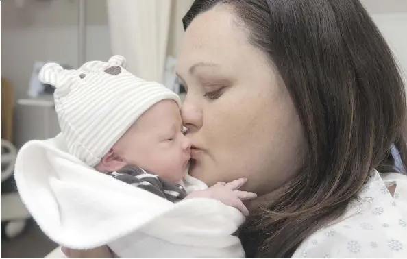  ?? DAVID BLOOM ?? Melissa Taylor kisses son Eli Danny Roy Mercer, the first baby to be born in Fort McMurray since the wildfire evacuation on May 3.
