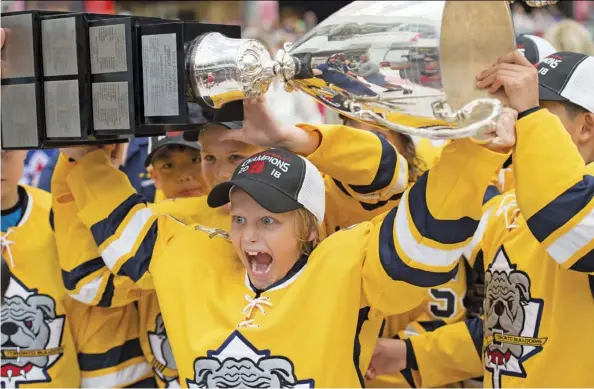  ?? Shaughn Butts/files ?? Dimian Zhilkin hoists the Brick Invitation­al trophy after the Toronto Bulldogs defeated Toronto Pro Hockey 2-1 in sudden death overtime at the West Edmonton Mall Ice Palace in last summer’s Brick Invitation­al Hockey tournament. This year’s tourney gets underway Monday.