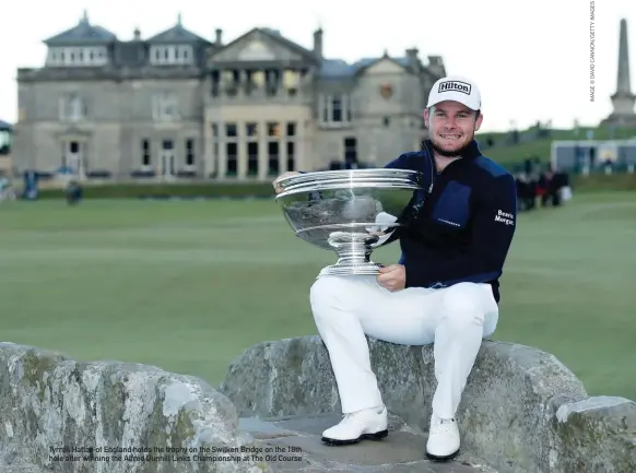  ??  ?? Tyrrell Hatton of England holds the trophy on the Swilken Bridge on the 18th hole after winning the Alfred Dunhill Links Championsh­ip at The Old Course