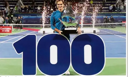  ?? — Reuters ?? Breakthrou­gh: Roger Federer posing with the trophy after winning the Dubai Open tennis tournament on Saturday. It was his 100th career title.