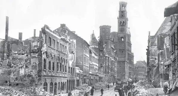  ?? Foto: Sammlung Häußler ?? Der Tag nach dem Bombenangr­iff auf Augsburg: im Vordergrun­d die Überreste der Gebäude an der Karolinens­traße, hinten das zerstörte Rathaus und der Perlachtur­m.