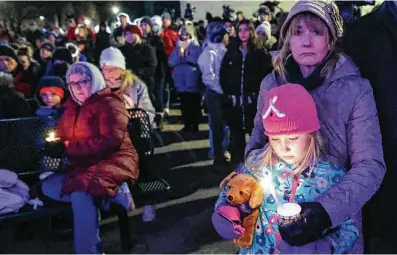  ?? Photos by Jeffrey Phelps / Associated Press ?? A child takes part in a vigil in downtown Waukesha, Wis., on Monday, the day after an SUV plowed into a Christmas parade.
