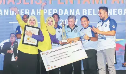  ?? — Gambar Bernama ?? TAHNIAH: Ahmad Zahid menyampaik­an Anugerah Perdana Belia Negara 2017 kategori pertubuhan kepada Kelab Beliawanis Sri Sepang sempena sambutan Hari Belia Negara, baru-baru ini.