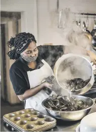  ??  ?? FIRM FAVOURITE. Emily, a cook at Wolfgat, with a steaming load of freshly cooked mussels in the kitchen.