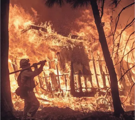  ??  ?? Firefighte­r Jose Corona battles a fire that consumed a home in Magalia, Calif.