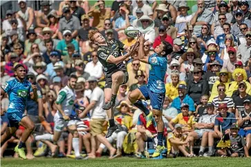  ?? PHOTOS: WARWICK SMITH/STUFF ?? Hurricanes halfback Finlay Christie, left, and Blues first five-eighth Stephen Perofeta contest a high ball during their pre-season clash at Mangataino­ka.