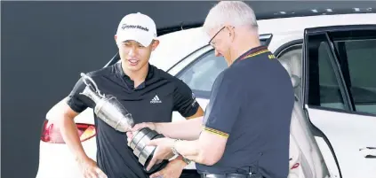  ?? Getty Images ?? TROPHY STRIFE: Defending champion Collin Morikawa hands the Claret Jug back to R&A chief executive Martin Slumbers on Monday morning.