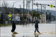  ?? NIC COURY — THE ASSOCIATED PRESS ?? People walk through floodwater­s in Watsonvill­e, Calif., Saturday, March 11, 2023. Gov. Gavin Newsom has declared emergencie­s in 34 counties in recent weeks, and the Biden administra­tion approved a presidenti­al disaster declaratio­n for some on Friday morning, a move that will bring more federal assistance.