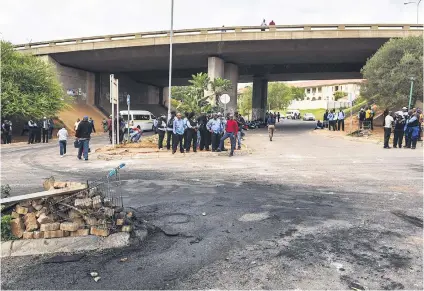  ?? Picture: Jacques Nelles ?? AFTERMATH. Security workers amid the debris after a protest outside the Steve Biko Academic Hospital in Pretoria yesterday. The security guards were protesting the non or partial payment of salaries this month by Born to Protect, the company that...