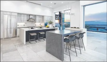  ?? Corcoran Global Living ?? In the spacious kitchen there is a Kelly Wearstler Avant linear pendant over the island. The front island features a charcoal-colored counter.