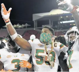  ?? JAMIE RHODES ?? Hurricanes linebacker Zach McCloud (53) celebrates with the turnover chain against Louisville on Sept. 19.