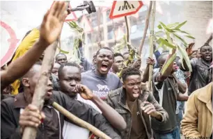  ?? Photo: AFP ?? Supporters of the Kenyan opposition presidenti­al candidate shout and hold sticks during a protest in the Mathare slums of Nairobi yesterday.