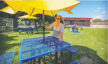  ?? JOHN MAHONEY ?? Lester B. Pearson School Board art therapist Melanie Forest and husband Michael Louvaris assemble tables for an outdoor classroom at Maple Grove elementary school in Lachine last week. As schools prepare for children to return to school, some parents are calling for greater safety measures to minimize the spread of COVID-19, saying the government guidelines aren’t enough.