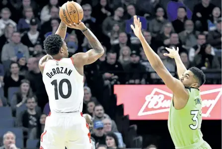  ?? JIM MONE/THE ASSOCIATED PRESS ?? Toronto Raptors’ DeMar DeRozan, left, shoots over Minnesota Timberwolv­es’ Karl-Anthony Towns in the first half of an NBA basketball game on Saturday, in Minneapoli­s.