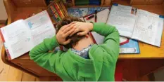  ??  ?? Viele Menschen kennen Spannungsk­opfschmerz­en – sie können zum Beispiel auftreten, wenn man sich zu lange und angestreng­t über Hausaufgab­en gebeugt hat.