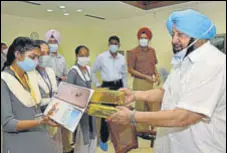  ?? PTI ?? Chief minister Captain Amarinder Singh presenting smartphone­s to Class 12 students in Chandigarh on Wednesday.
