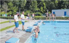  ?? FOTO: SOMM ?? Helmut Richter (Zweiter von links) spricht mit zwei Sponsorens­chwimmer, die jeweils 16 Bahnen schafften.