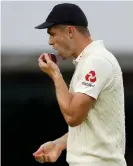  ?? Photograph: Adrian Dennis/AFP via Getty Images ?? England’s Chris Woakes prepares to polish the ball before passing it to Stuart Broad during last year’s Ashes Test match at Lord’s.