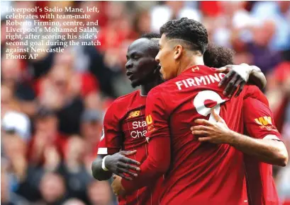  ??  ?? Liverpool’s Sadio Mane, left, celebrates with team-mate Roberto Firmino, centre, and Liverpool’s Mohamed Salah, right, after scoring his side’s second goal during the match against Newcastle
Photo: AP