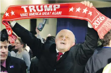  ??  ?? A supporter holds a sign touting Republican presidenti­al candidate Donald Trump during a rally in Manchester, New Hampshire, on Tuesday.