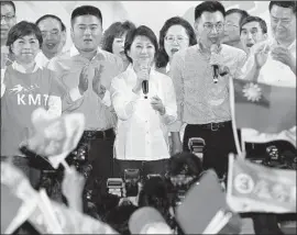  ?? AFP/Getty Images ?? LU SHIOW-YEN, center, of the Nationalis­t Party appears after her victory in the Taichung mayor’s race. Taiwan’s president resigned as chair of the ruling party.