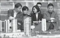  ?? LONG WEI / FOR CHINA DAILY ?? Potential homebuyers check details with a salesperso­n at a residentia­l project’s sales office in Hangzhou, Zhejiang province.