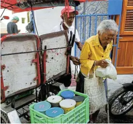  ?? /Reuters ?? Support for the needy: A woman carries a bag holding containers with food from a soup kitchen run by religious group Quisicuaba that is feeding a growing number of Cubans.