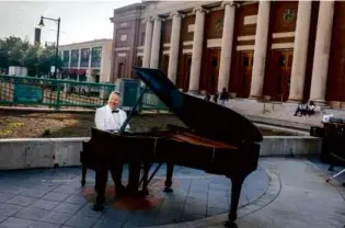  ?? ERIN CLARK/GLOBE STAFF ?? Ben Cook, a pianist for the Boston Pops and the BSO, played outside Symphony Hall to promote a large-scale sale of pianos.