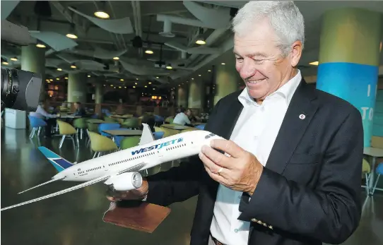  ?? JIM WELLS ?? WestJet chairman Clive Beddoe holds a model of a Boeing 787 Dreamliner in Calgary on Tuesday. The firm is betting on overseas travel for growth with its purchase of the aircraft.