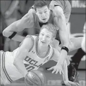  ?? Mark J. Terrill Associated Press ?? UCLA CENTER Thomas Welsh goes low for the ball aainst Oregon State forward Drew Eubanks.