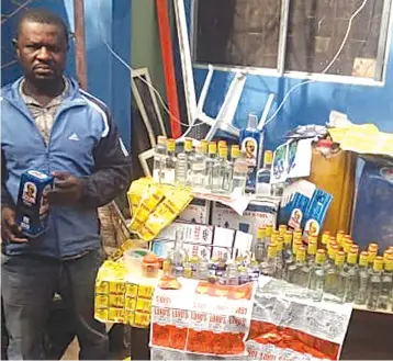  ??  ?? AN unidentifi­ed man sells the fake smuggled whisky and brandy in Mutare’s Sakubva high-density suburb