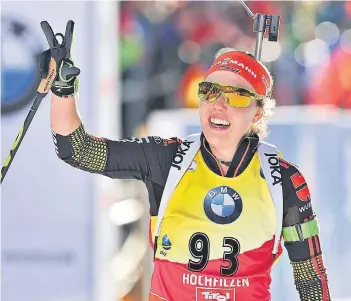  ??  ?? Da ist die Nummer drei: Biathletin Laura Dahlmeier zeigt dem Publikum nach ihrem Einzelsieg über 15 Kilometer die Anzahl ihrer Goldmedail­len bei der WM in Hochfilzen.