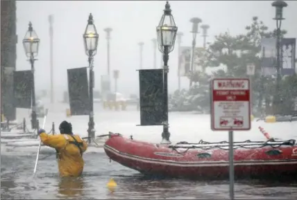  ?? MICHAEL DWYER, THE ASSOCIATED PRESS ?? A Boston firefighte­r wades through flood waters from Boston Harbour on Long Wharf in Boston, Thursday.