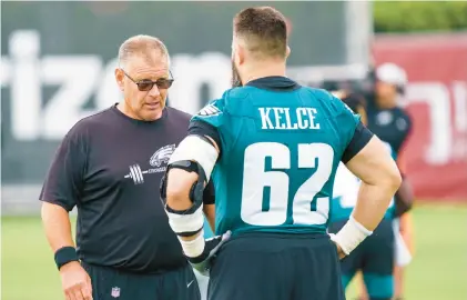  ?? CHRIS SZAGOLA/AP ?? Eagles offensive line coach Jeff Stoutland talks with center Jason Kelce during training camp. The players give Stoutland all the credit for the line’s success.