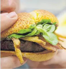  ?? FOTOS: DPA ?? Ein Burger mit Pommes und Cola hat rund 1000 Kalorien. Eine gesunde Fast-Food-Variante könnte ein Salat sein. Aber Achtung bei der Wahl des Dressings. Denn da verstecken sich die Kalorien.