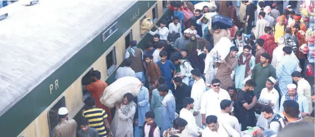  ?? ?? Karachi: People boarding on train at Railway Station to leave for their hometowns to celebrate Eid-ul-Fitr with their loved ones. — NNI