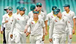  ?? — AP ?? Australia’s David Warner (centre) leaves the field with teammates at the end of the fifth and final day of the first Test at Kingsmead stadium in Durban.