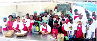  ?? FILE ?? Team Jamaica Bickle Ambassador Romain Virgo, shares a light moment with Team Jamaica Bickles staff, who catered for the athletes while at The Penn Relays in Philadelph­ia last year.