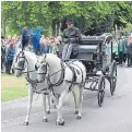  ??  ?? Horses pull the hearse.