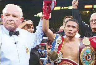  ?? PHOTO COURTESY pHILBOXING.COM ?? Referee Lou Moret raises the hands of Donnie Nietes after Nietes’s victory over Edgar Sosa Saturday night in Carson, California.