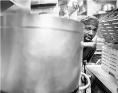  ??  ?? Dishwasher Sylla works in the kitchen of Daniel, one of chef Daniel Boulud’s restaurant­s in New York.