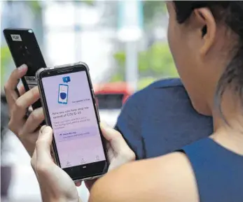  ?? FOTO: CATHERINE LAI/AFP ?? Vorbilder in Asien: Eine von der Regierung mitentwick­elte Tracking-App, mit der die sozialen Kontakte von Smartphone­Nutzern nachvollzo­gen werden können, wurde am 20. März im Stadtstaat Singapur vorgestell­t.