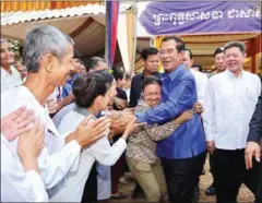  ?? FACEBOOK ?? Hun Sen greets members of the public at the inaugurati­on of a temple in Kampong Cham yesterday. In a speech there, he said the country’s 200,000 civil servants will receive at Khmer New Year bonus equal to $12.50.