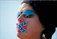  ?? ROGELIO V. SOLIS/AP ?? A demonstrat­or wears a Confederat­e battle flag sticker during a silent protest of the current Mississipp­i state flag at the opening of two museums in Jackson on Saturday.