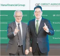  ?? Courtesy of Hana Financial Group ?? Hana Financial Group Vice Chair Lee Eun-hyung, right, poses with Credit Agricole Corporate and Investment Bank CEO Xavier Musca at the signing ceremony for their MOU agreement held at the headquarte­rs of Credit Agricole CIB in Montrouge, France, Wednesday.