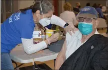  ?? RACHEL RAVINA - MEDIANEWS GROUP ?? Volunteer Susan Ligget, left, administer­s a COVID-19vaccine to Robert Heymer, an 88-year-old Korean War veteran, Sunday morning during a temporary vaccinatio­n clinic at North Penn High School in Lansdale.