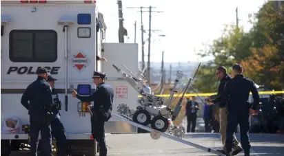  ?? (Mark Makela/Reuters) ?? LAW ENFORCEMEN­T personnel operate a bomb disposal robot outside a post office which had been evacuated on yesterday in Wilmington, Delaware.