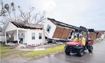  ?? WIN MCNAMEE/GETTY ?? A Texas search team works outside a heavily damaged home Wednesday in Golden Meadow, La.