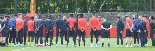  ?? — AFP ?? Manchester United players observe a minute’s silence for the victims of Monday’s terror attack in Manchester, at a training session on Tuesday.